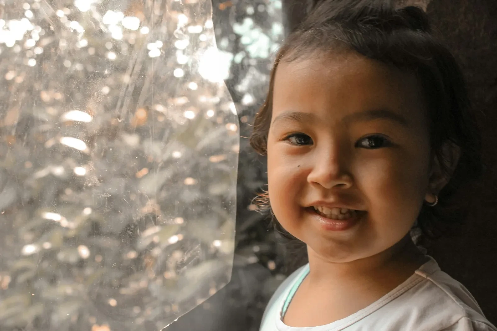 a girl smiling with a tree in the background