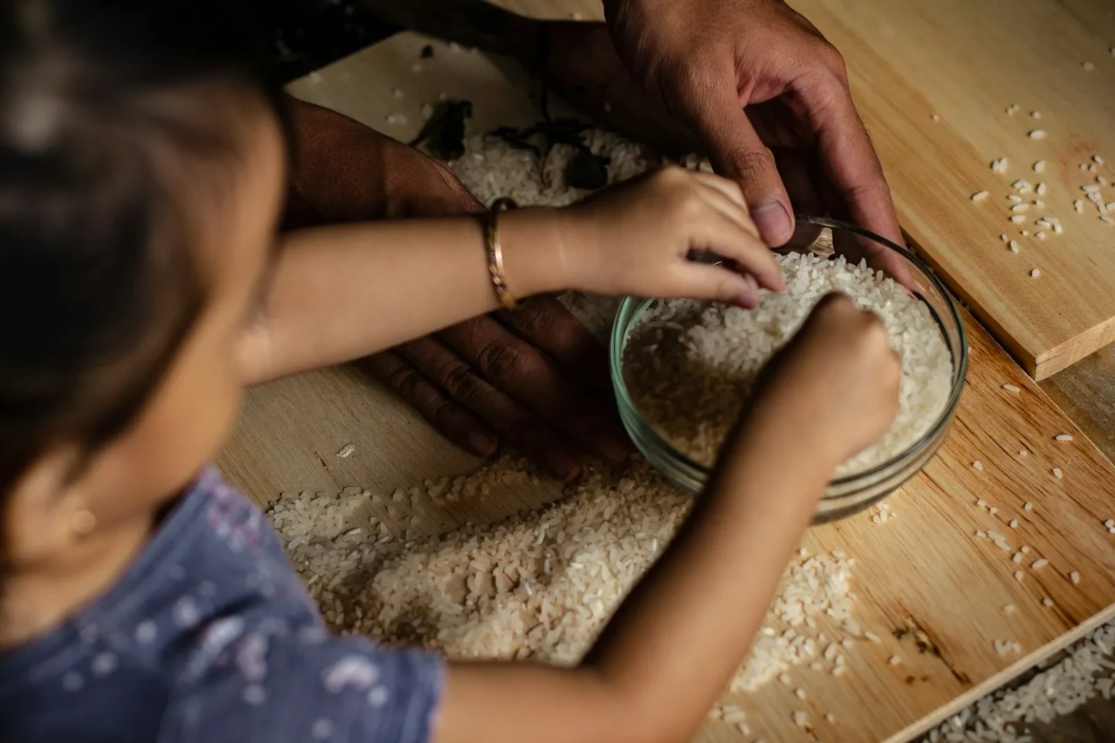 person holding white powder on brown wooden table