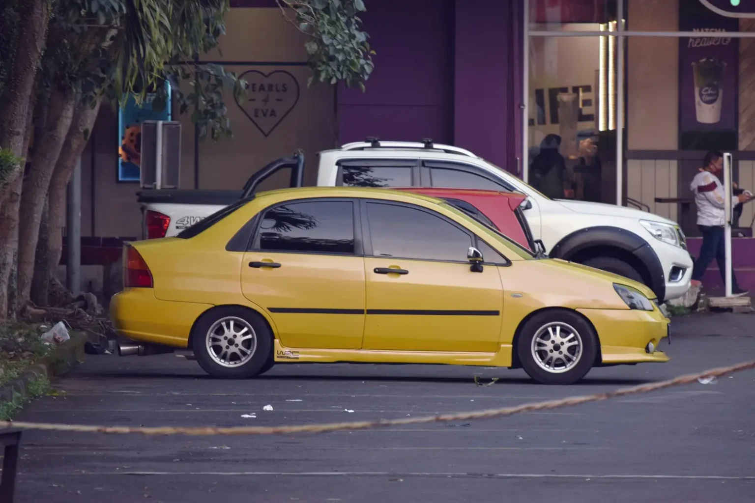 yellow sedan on gray asphalt road during daytime