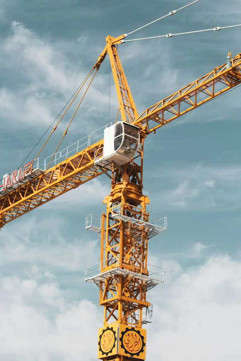 yellow and black crane under cloudy sky during daytime