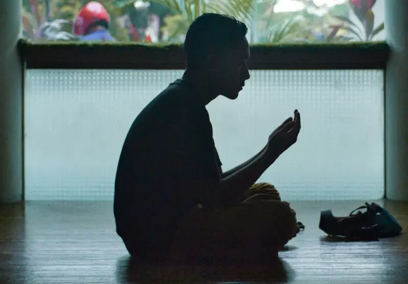 man in black shirt sitting on floor