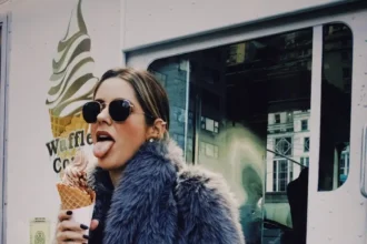 a woman in a fur coat eating an ice cream cone