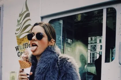 a woman in a fur coat eating an ice cream cone