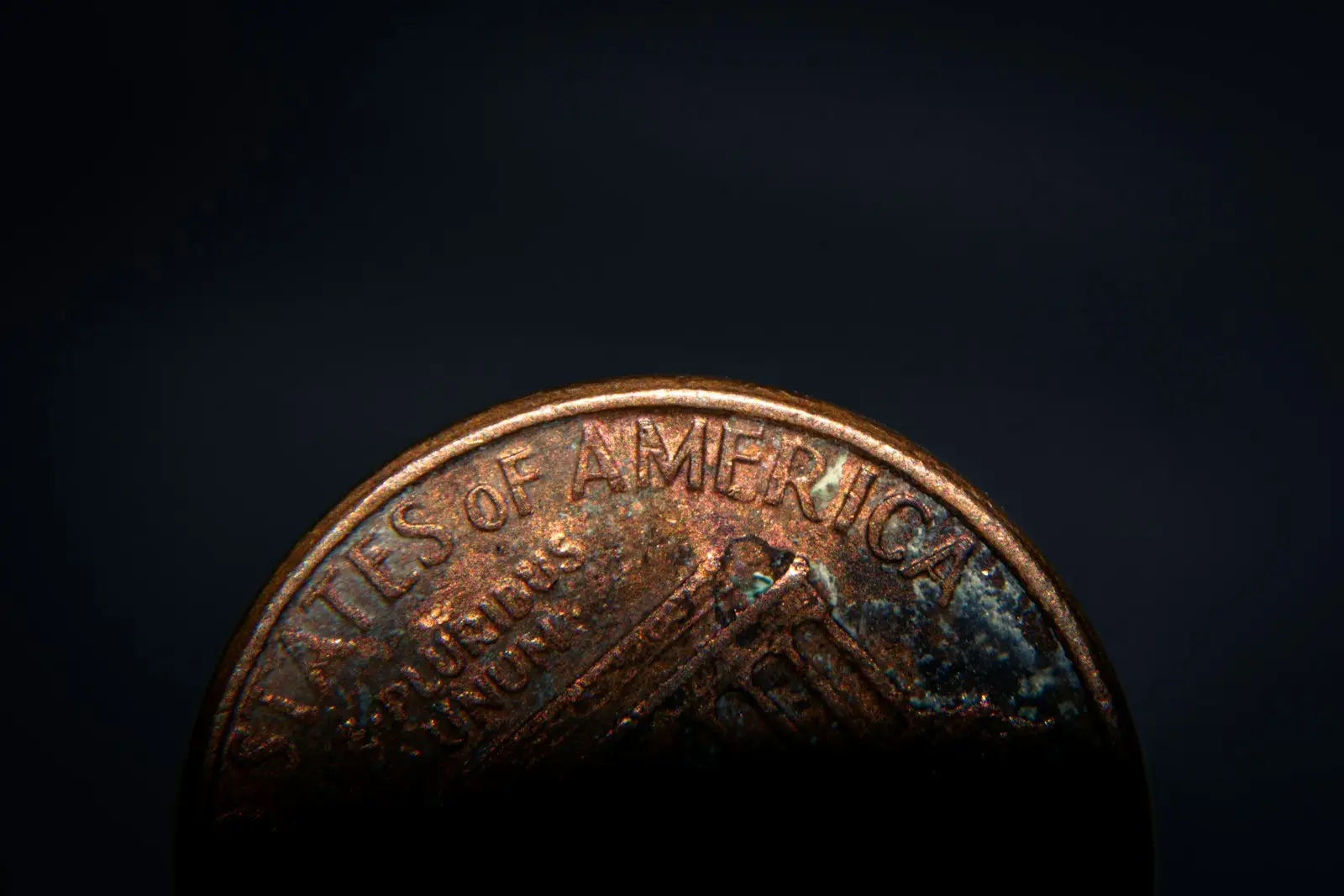 a close up of a penny on a black background